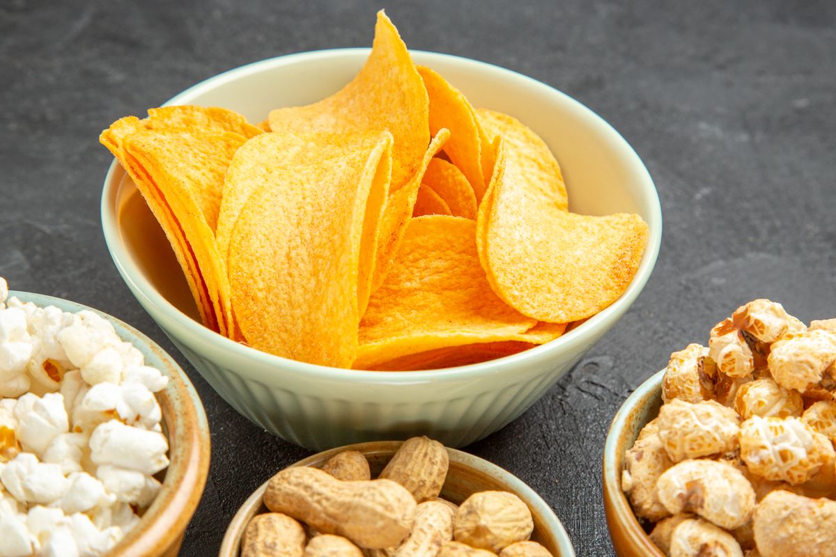 Chips, Popcorn und Erdnüsse in Schalen